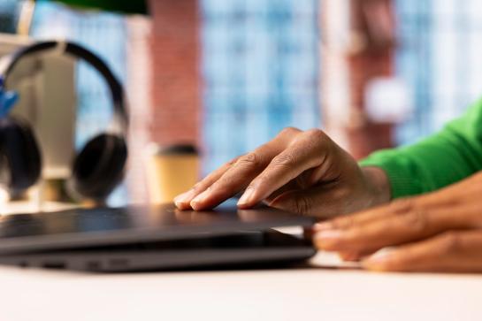 Man met groene trui opent laptop